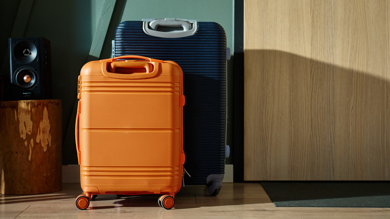 Orange and blue suitcases beside a door