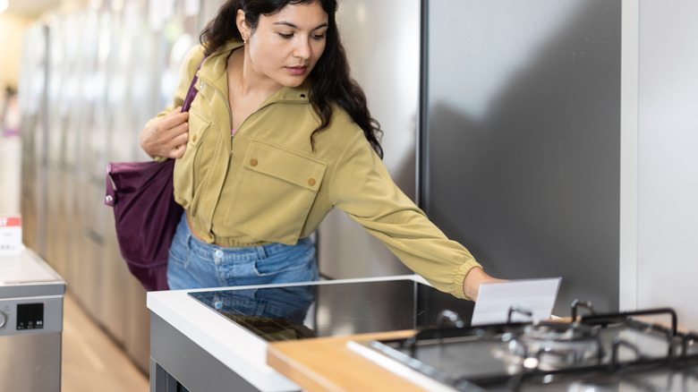 Woman considering an induction cooktop in an appliance store