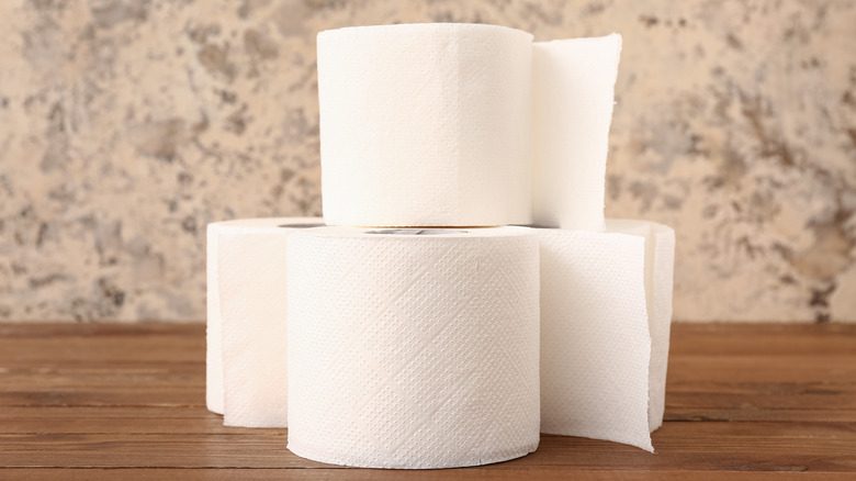 A small stack of toilet paper on a wooden table