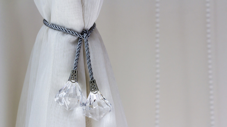 White sheer curtain tied with decorative cord