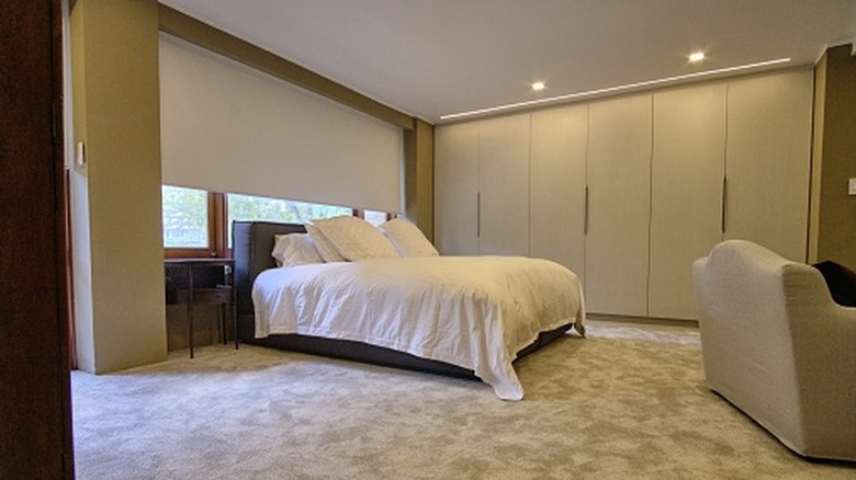 A bedroom with beige carpet