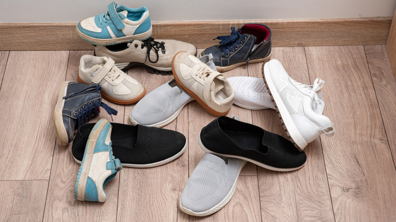 Pile of assorted shoes cluttering a floor