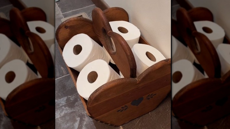 thrifted wooden magazine rack being used as a toilet paper holder