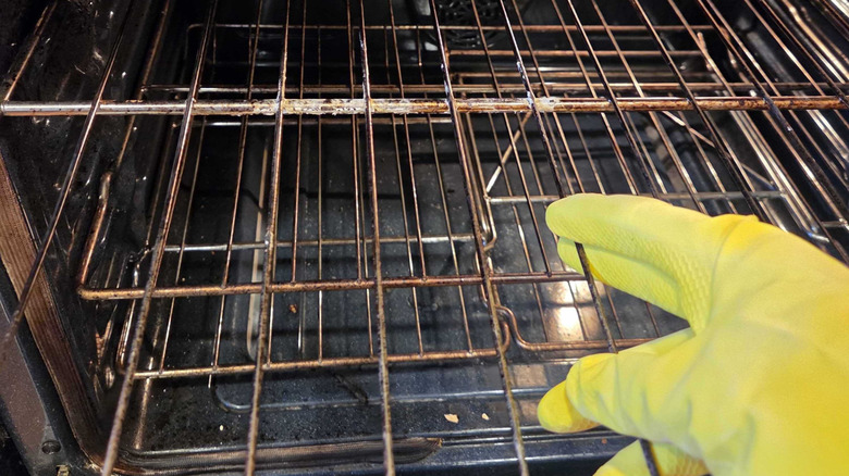 a rubber glove and a dirty oven rack
