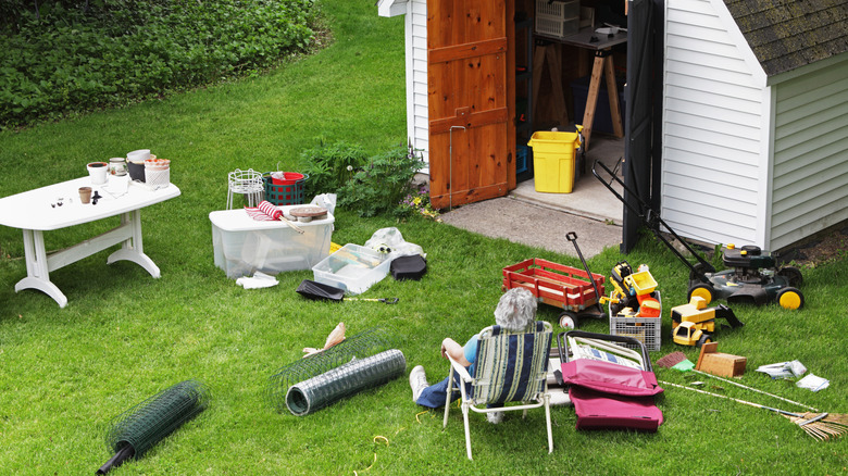Person taking a break while cleaning out a backyard storage area