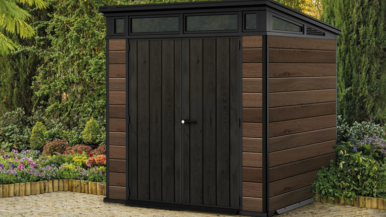 Keter DecoCoat outdoor shed wit flowers and trees around it