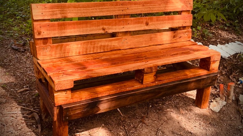 A bench made out of wood pallets outdoors