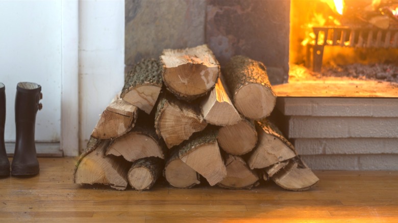 firewood stacked on floor in front of fire