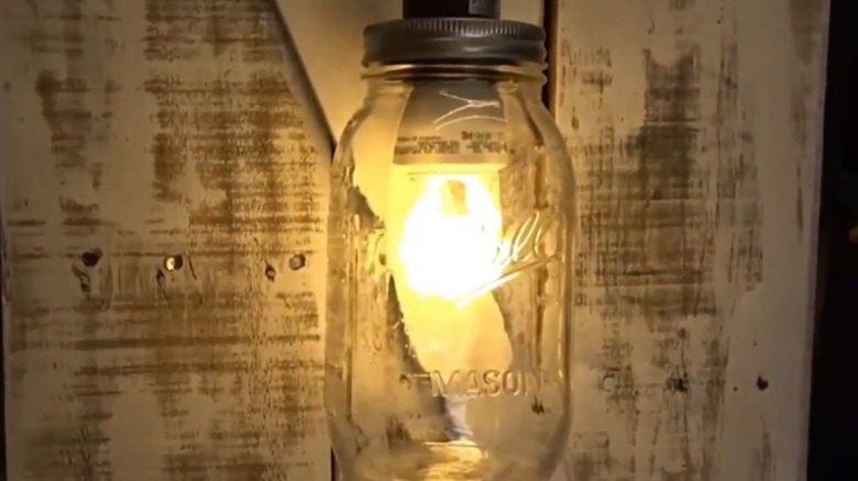 Mason jar hanging light in front of rustic wood