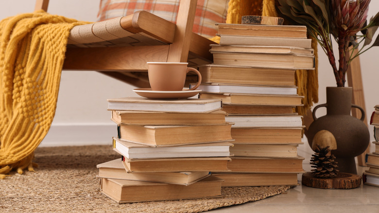 books stacked on floor beside chair