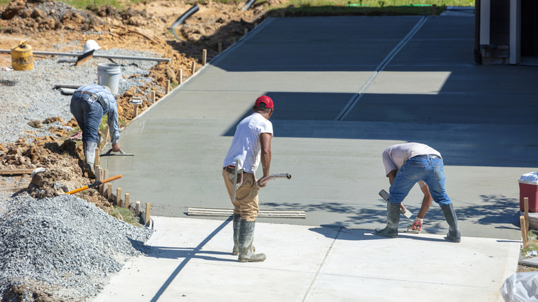 Workers paving a concrete driveway