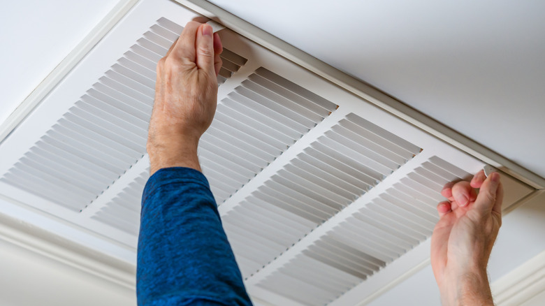 Man taking air vent off for cleaning