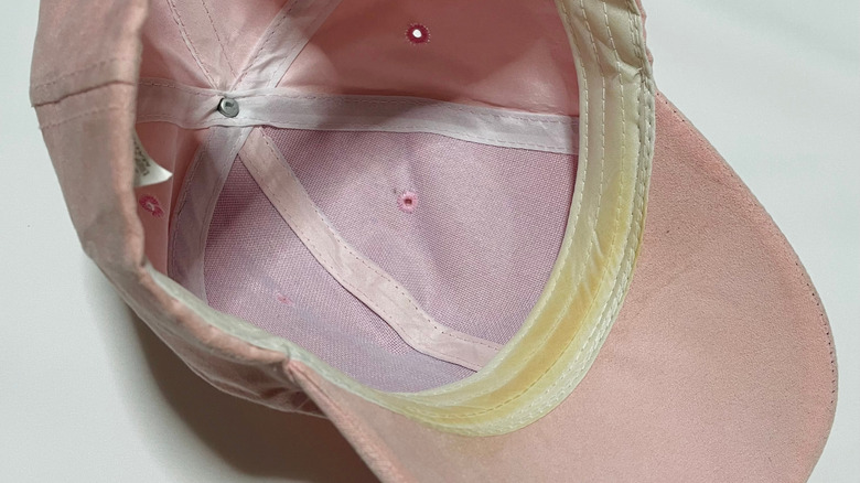 Pink baseball hat with a visible sweat stain under the brim