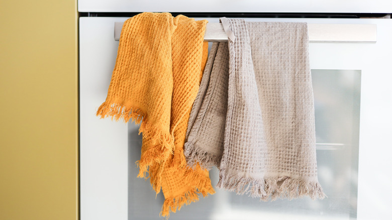 Yellow and tan towels hanging on oven handle