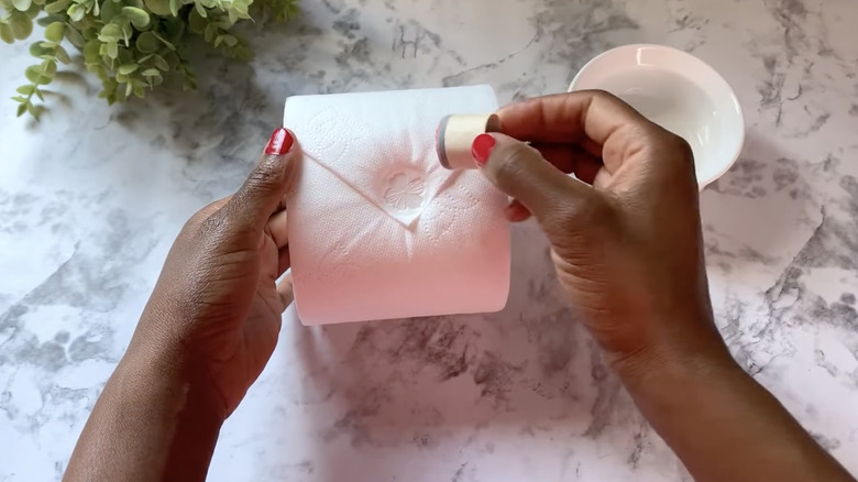 hands stamping toilet paper roll