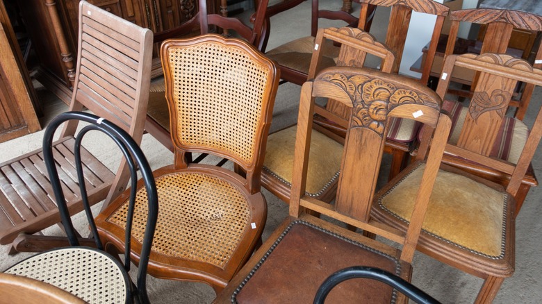 Vintage solid-back and wicker chairs at a thrift store