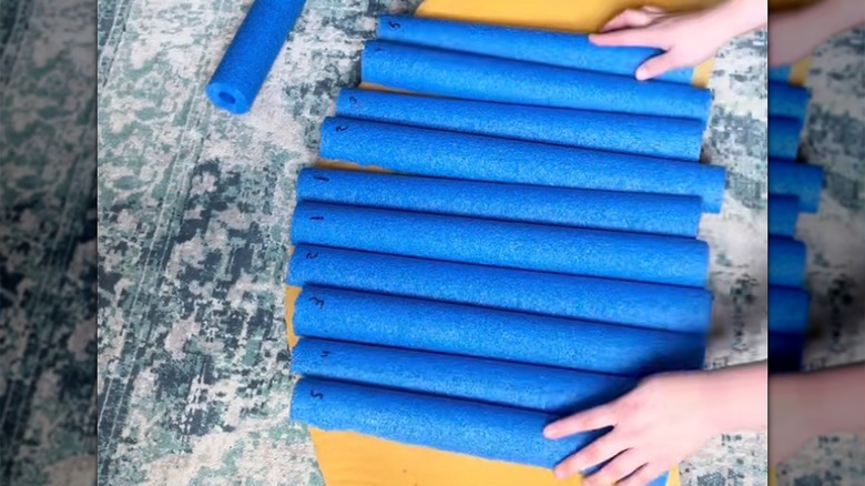 Woman arranging pool noodles on foam backing