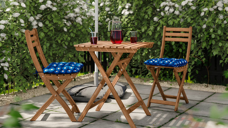 IKEA ASKHOLMEN table and chairs with blue cushions, outdoors