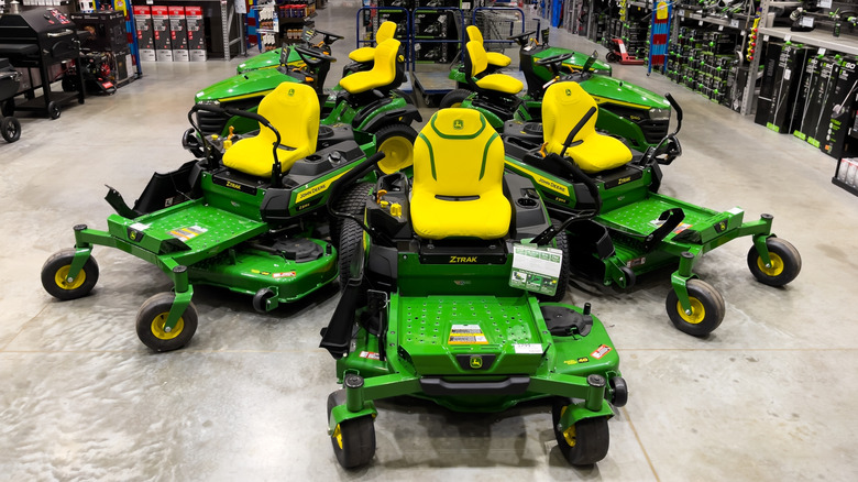A display of John Deere zero-turn mowers at a retail store