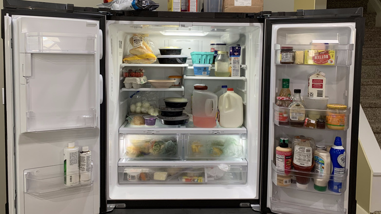 an open, cluttered refrigerator