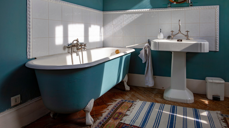 Small bathroom with pedestal sink and tub and no cabinets