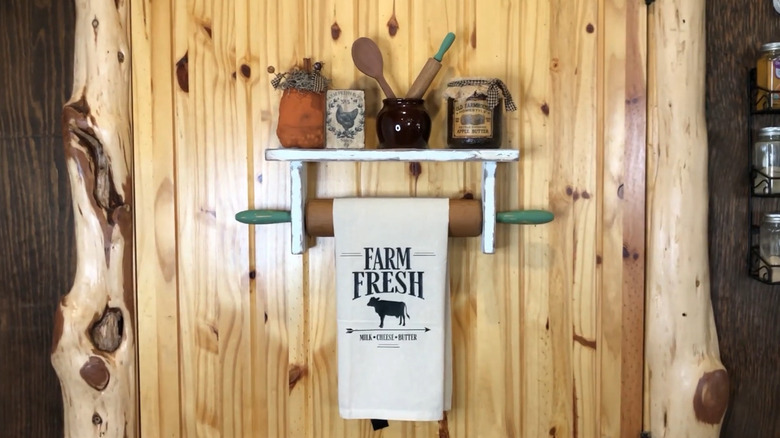 A wall-mounted paper towel holder with the dowel replaced by a rolling pin