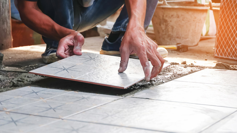 a person lays tiles during a bathroom remodel