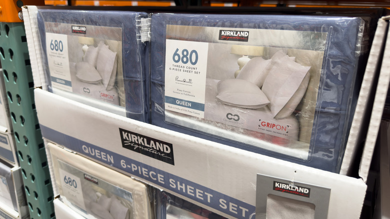 Kirkland brand bed sheet set packages on shelf at Costco.