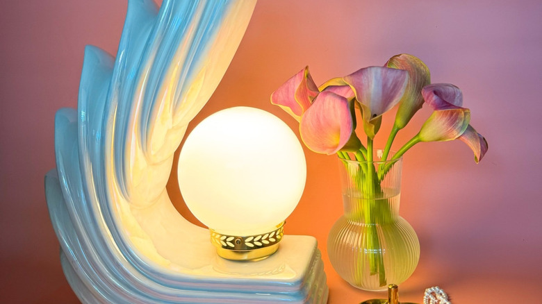 An iridescent cascade wing lamp with vase of flowers