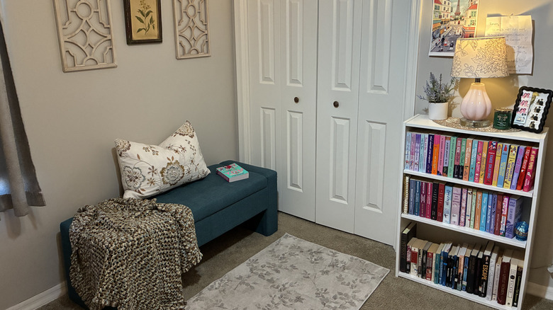 Finished DIY reading nook with a bookcase, storage bench, and wall art