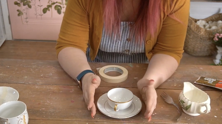 person at DIY table with teacups and tape