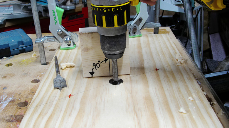 Boring a hole into wood at 90 degrees to the surface using a guide