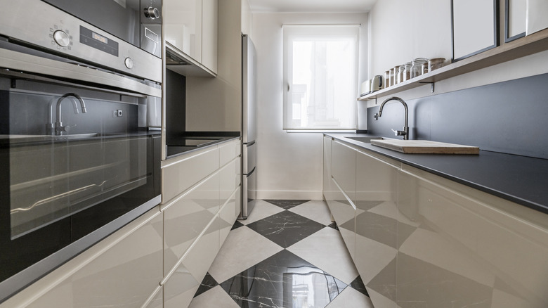 A small kitchen with black-and-white checkered porcelain tiled floors
