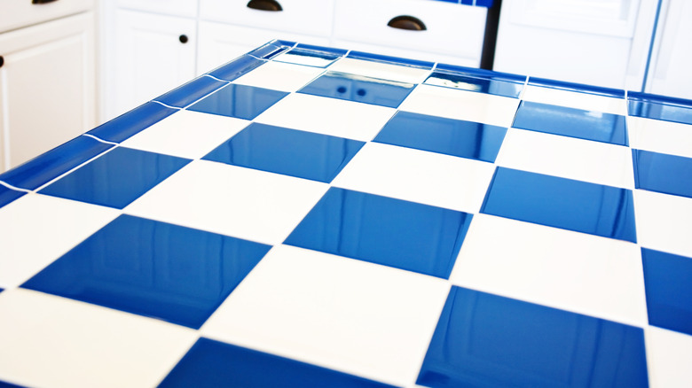 Kitchen counter with wide checkered tiles.