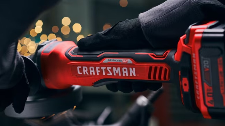 A person wearing black gloves uses a Craftsman Cordless Angle Grinder