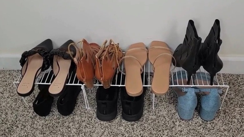 Shoe rack made of wire shelves with shoes on top and underneath
