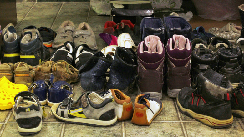 Collection of shoes cluttering entryway.
