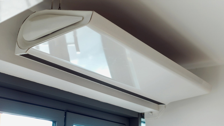 Electrically powered air curtain over doorway