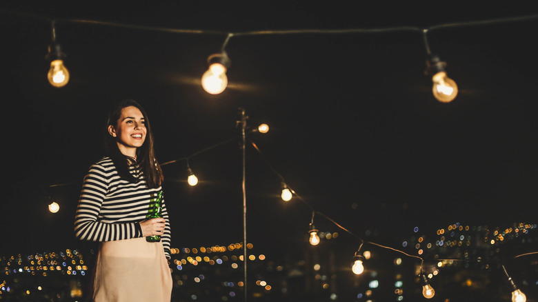 Girl on a roof with bistro lights