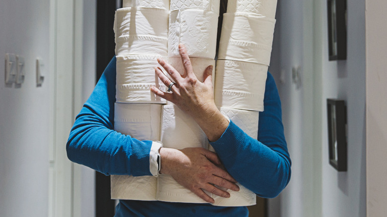 Person holding rolls of toilet paper