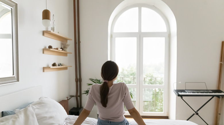 Woman looking at sunburst window
