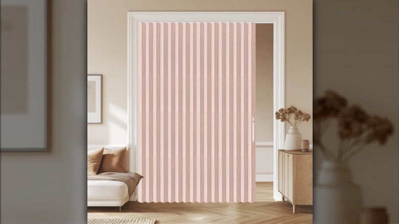 Pink AJAZZ folding accordion door half-closed in the doorway.
