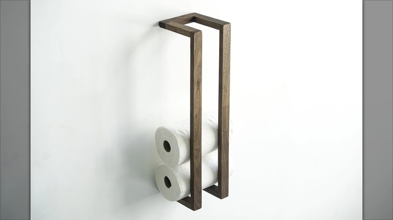 A vertical towel rack stocked with two paper towel rolls
