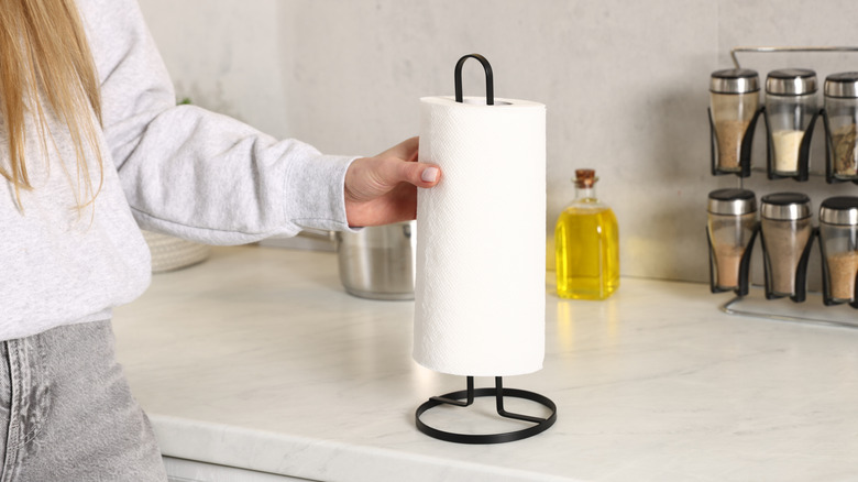 Woman reaching for a paper towel in the kitchen