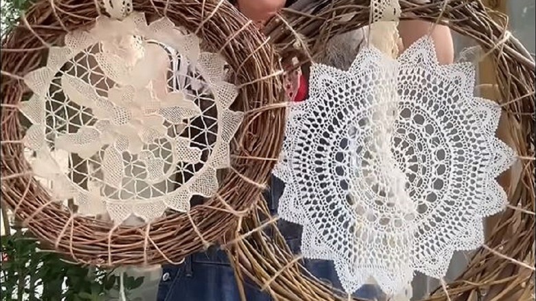 Woman holding DIY doily wreaths to use as yard decor