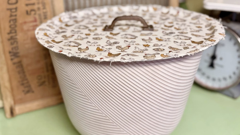 A DIY pot lid made out of a pizza pan on top of a planter