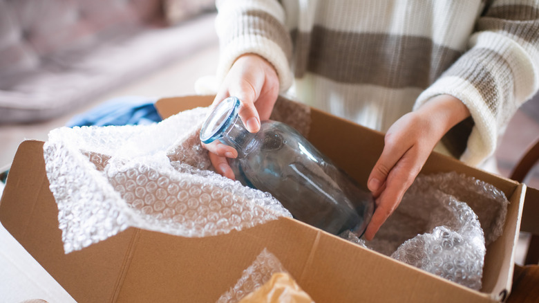 person unpacking glassware from carton