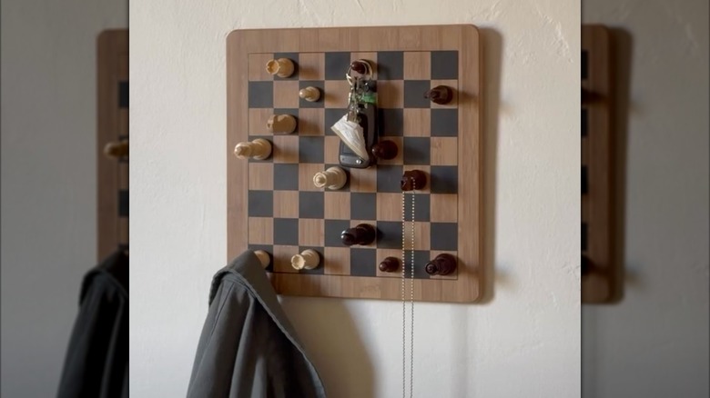 A gray coat and accessories hang from a DIY chessboard coat rack