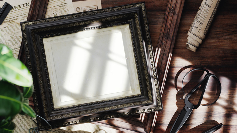 Vintage frame and scissors on table