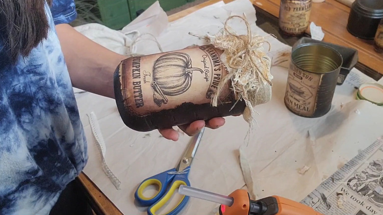 Woman putting finishing touches on vintage mason jar project for countertop decor